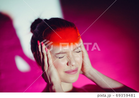Young woman with headache and red color forehead 69359481