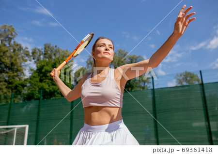Beautiful female tennis player serving outdoor Beautiful female tennis player serving outdoor 69361418