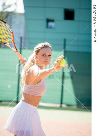 Woman serving the ball for a game of tennis on court Woman serving the ball for a game of tennis on court 69362091