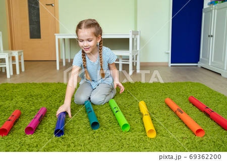 girl playing with colourful musical tubes. 69362200
