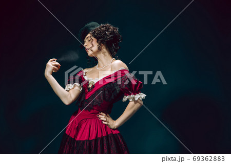 Young woman as Anna Karenina on dark blue background. Retro style, comparison of eras concept. 69362883