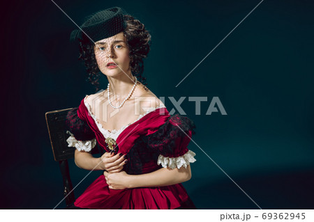 Young woman as Anna Karenina on dark blue background. Retro style, comparison of eras concept. Young woman as Anna Karenina on dark blue background. Retro style, comparison of eras concept. 69362945