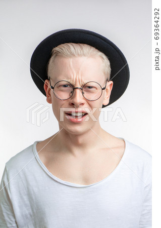 Annoyed blond male in black hat with frowned face as recieving unpleasant news Annoyed blond male in black hat with frowned face as recieving unpleasant news 69364292