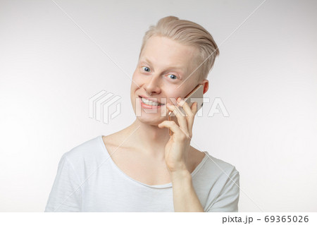 Young cheerful businessman typing sms on his smartphone Young cheerful businessman typing sms on his smartphone 69365026