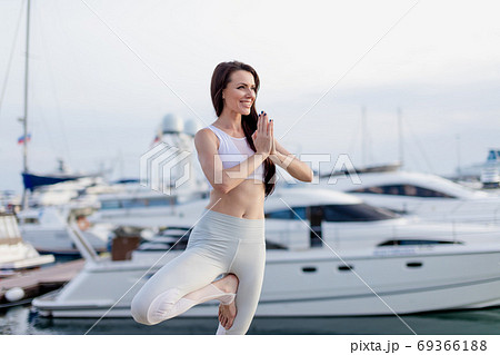 Woman working out outdoors, doing yoga exercise, Tree Pose at Navy Pier 69366188