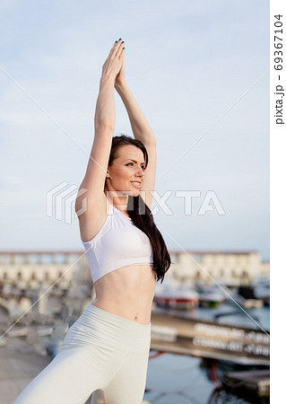 Woman working out outdoors, doing yoga exercise, Tree Pose at Navy Pier 69367104