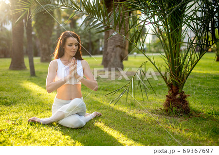 Fitness woman training yoga in cow head pose in nature background. 69367697