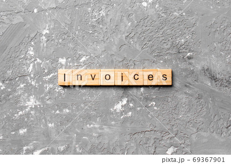 INVOICES word written on wood block. INVOICES text on cement table for your desing, concept 69367901