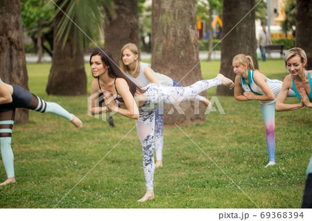 Yoga classes outdoor at park. Group of women exercising outdoors. Yoga classes outdoor at park. Group of women exercising outdoors. 69368394