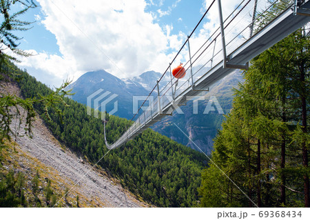 Charles Kuonen suspension bridge in Swiss Alps. With 494 metres, it is the longest suspension bridge in the world in summer landscape 69368434