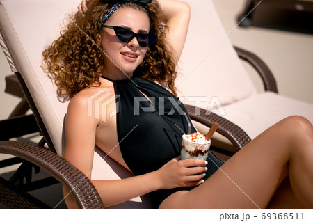 The sunbathing woman near a swimming pool The sunbathing woman near a swimming pool 69368511
