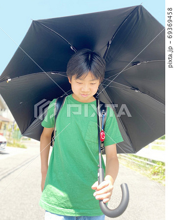 猛暑の中を日傘で歩く小学生 猛暑の中を日傘で歩く小学生 69369458