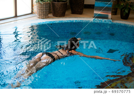 Woman chilling in indoor Pool At Luxury Resort. Woman chilling in indoor Pool At Luxury Resort. 69370775
