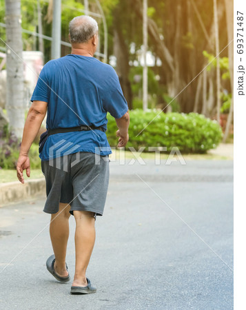 Back view portrait of a Asian elderly man in fitness wear walking and jogging for good health in public park. Senior jogger in nature. Older Man enjoying Peaceful nature. Healthcare concept. Back view portrait of a Asian elderly man in fitness wear walking and jogging for good health in public park. Senior jogger in nature. Older Man enjoying Peaceful nature. Healthcare concept. 69371487
