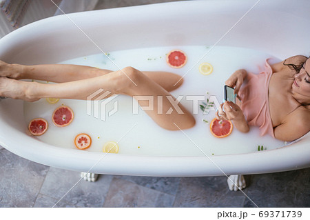 pretty woman using mobile phone while having a bath at home 69371739