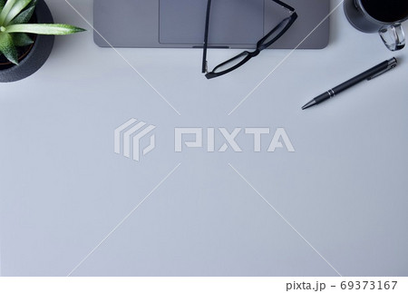A worktable with laptop, glasses, flower, pen and mug of proper coffee and a place for your own text A worktable with laptop, glasses, flower, pen and mug of proper coffee and a place for your own text 69373167