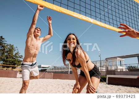 Summertime beach volleyball game in progress 69373425