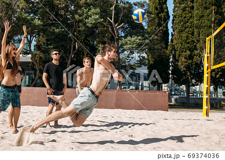 group of young people playing volleyball on the beach group of young people playing volleyball on the beach 69374036