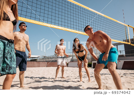 Summertime beach volleyball game in progress 69374042