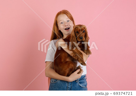Caucasian teen girl's portrait isolated on coral pink studio background. Caucasian teen girl's portrait isolated on coral pink studio background. 69374721