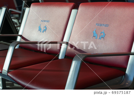 Red chairs with priority seats at the airport 69375187