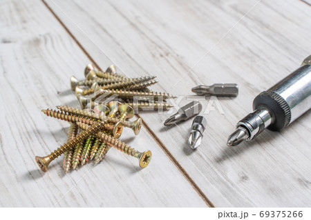 Group of Screw bolts with screwdriver on wooden background. Group of Screw bolts with screwdriver on wooden background. 69375266