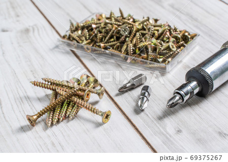 Group of Screw bolts with screwdriver on wooden background. Group of Screw bolts with screwdriver on wooden background. 69375267