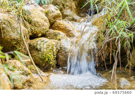 Mountain spring waterfall among the mossy stones 69375660