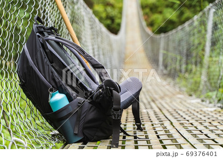 Backpack with water bottle on pedestrian suspension bridge 69376401