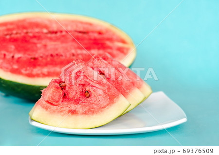 Water melon slices on a plate on blue background Water melon slices on a plate on blue background 69376509