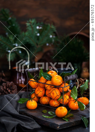Fresh ripe tangerines with leaves on wooden table 69376572