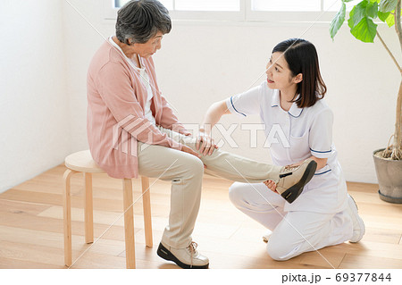 リハビリを介助する介護士 69377844