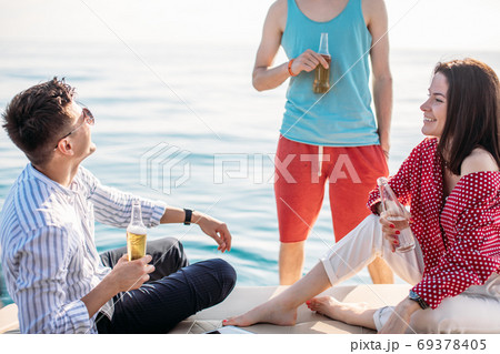 yacht drinking beers while talking Group of friends having party on sailing boat yacht drinking beers while talking Group of friends having party on sailing boat 69378405