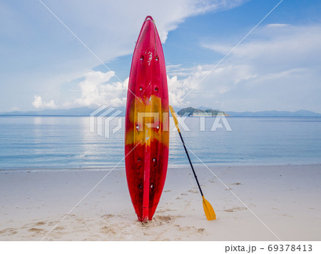 Red kayak on white sand beach at beauty day light, Travel plans in holidays or after retirement Red kayak on white sand beach at beauty day light, Travel plans in holidays or after retirement 69378413