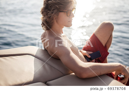 Young caucasian hipster guy enjoying journey on yacht deck sailing the sea. 69378708