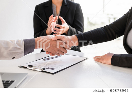 Shaking hands and clap after office executives are interviewing job applicants in the meeting room Shaking hands and clap after office executives are interviewing job applicants in the meeting room 69378945
