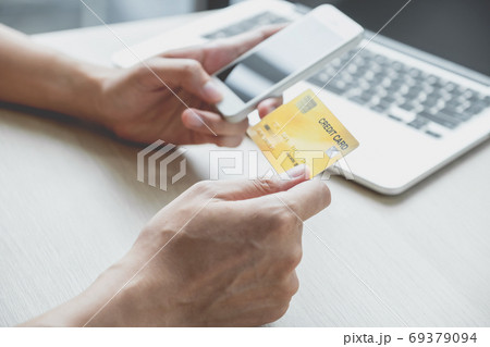 Businessman's hand typing laptop computer to online shopping with credit card from home Businessman's hand typing laptop computer to online shopping with credit card from home 69379094