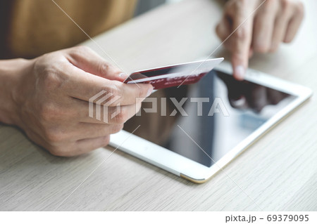 Businessman hand hold credit card to online shopping on computer tablet from home 69379095