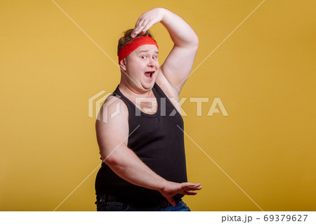 fat man makes kung-fu exercise, rise hands, crane pose 69379627