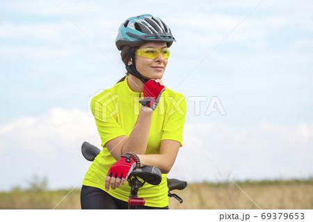 Beautiful girl cyclist with a bicycle on the nature. Healthy lif 69379653