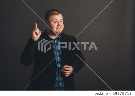 overweight young man pointing up overweight young man pointing up 69379713