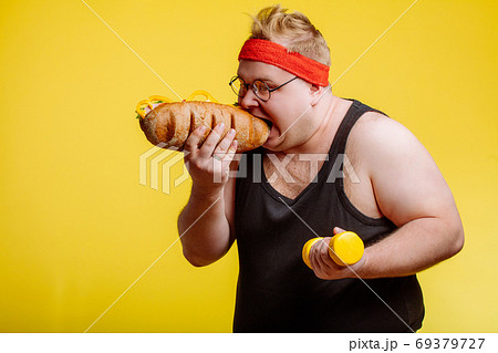 fat man eating fast food hamberger fat man eating fast food hamberger 69379727