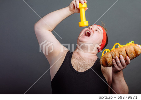 funny guy in sportswear eat small dumbbells funny guy in sportswear eat small dumbbells 69379871