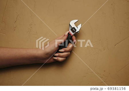Girl with a wrench. Tool for plumbing repair with their hands Wrench close-up in a woman hand. 69381156