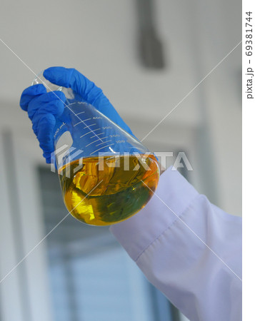 Closeup shot hand carrying conical flask Closeup shot hand carrying conical flask 69381744