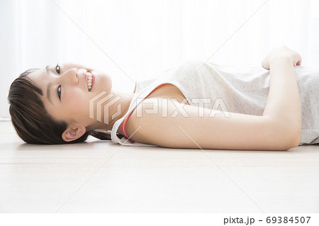 床に寝転がる女性 69384507