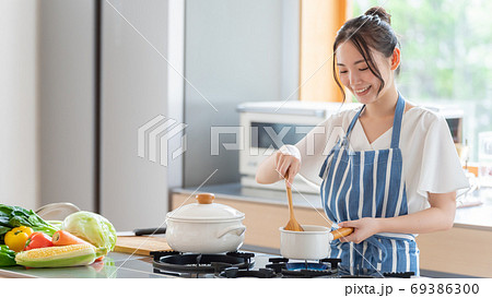 キッチンで料理をする女性 キッチンで料理をする女性 69386300