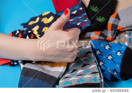 many colored socks laid out in a circle, female hand shows a gesture of approval, concept many colored socks laid out in a circle, female hand shows a gesture of approval, concept 69386898