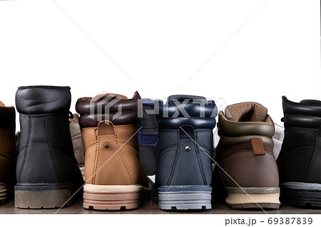 a lot of different shoes stand flush, the reverse side, in a row on a wooden board, concept, assortment of boots a lot of different shoes stand flush, the reverse side, in a row on a wooden board, concept, assortment of boots 69387839