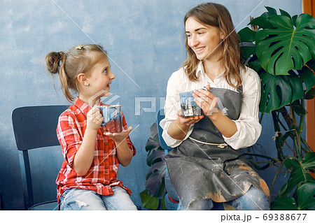 A woman with child makes dishes in a pottery 69388677